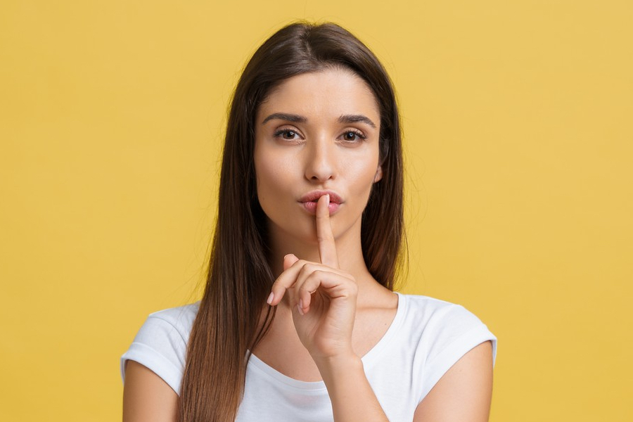 Mujer haciendo el gesto de guardar el secreto para adelgazar